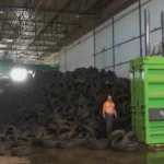 Montaña de neumáticos usados en planta de reciclaje con prensa de residuos LCC V85.
