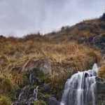 Pequeña cascada de agua natural de montaña árida que hace referencia a las ayudas de gestion de residuos por comiunidades autonomas