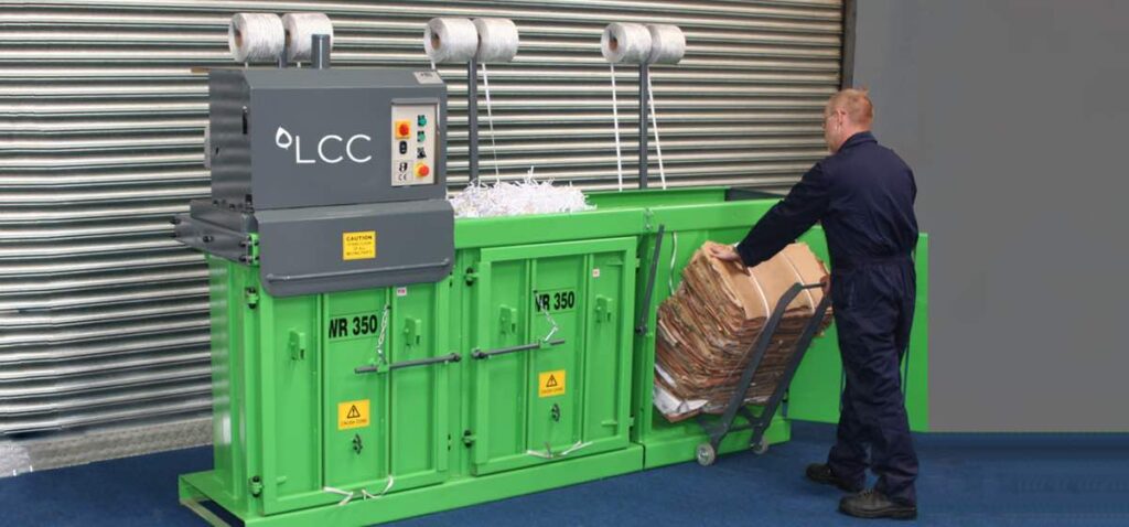 Compactadora vertical de cartón multicámara LCC en almacén de empresa.