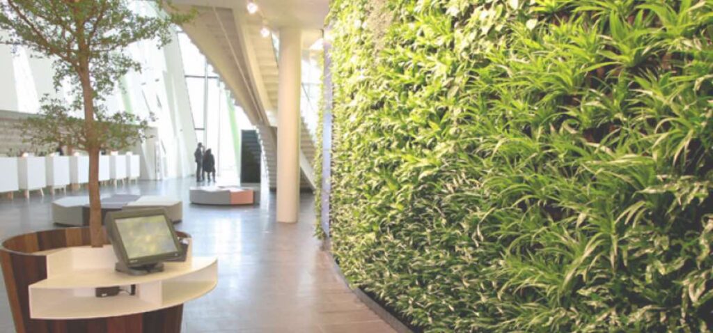 Recepción de hotel eco con jardín vertical en pared.
