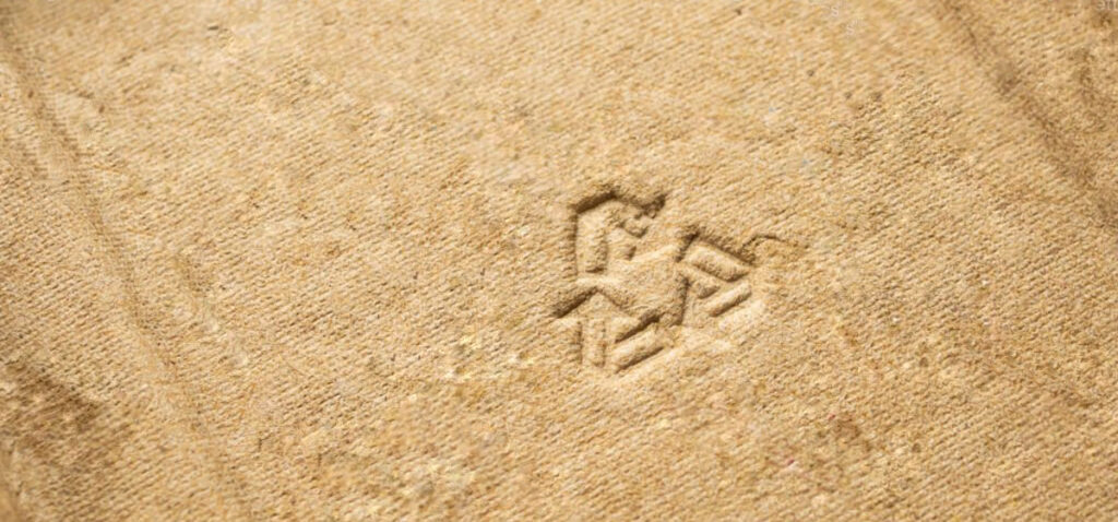 Detalle de cartón reciclado con símbolo de reciclaje